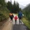 man, woman, and child walking together along dirt road